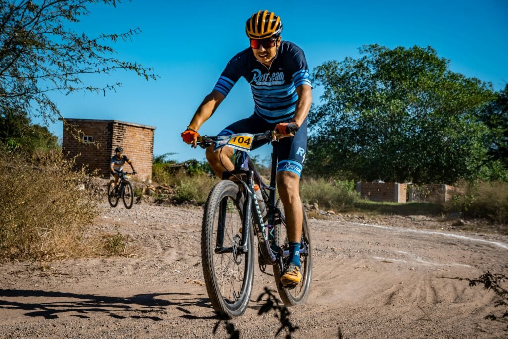 Male cyclists racing on a dirt trail, showcasing outdoor adventure and fitness.