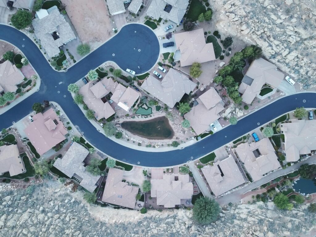Drone aerial photo of a suburban neighborhood street layout with houses and greenery.